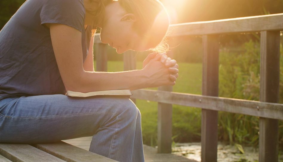 Mulher orando e buscando revelação se precisamos de um profeta.