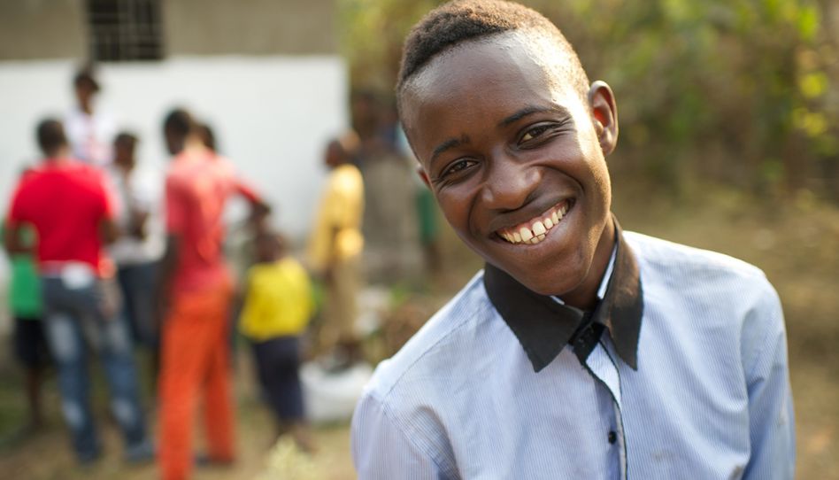 Jovem adulto solteiro sorri no Congo.